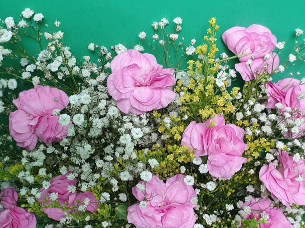 flor de clavel rosa en un ramo floral y fondo verde
 - Foto, imagen