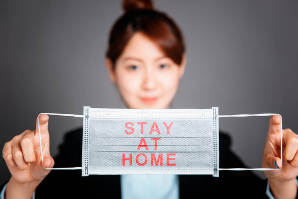 Business woman with protecting mask showing stay home and work at home concepts - Foto, immagini