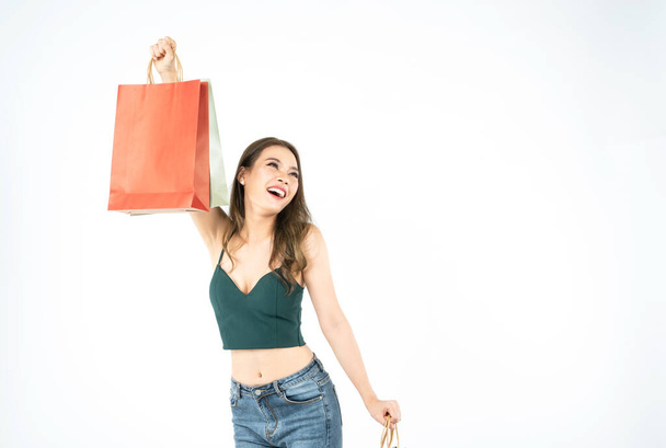 studio portrait of asian beautiful young woman in colorful outfit, holding shopping bag in hands laughing and looking very happy,sale excited, spring summer fashion trend isolated on white background. - Foto, Imagen