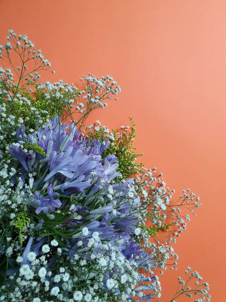paarse agapanthus bloem in een bloemig boeket en oranje achtergrond - Foto, afbeelding