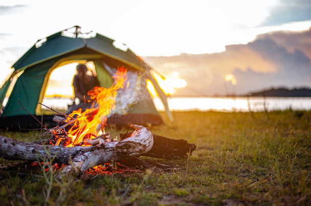 Camping bonfire surrounded by team of asian climbers hiker, they are playing music together in the forest path autumn season. Hiking, hiker, team, forest, camping , activity concept. - Photo, Image