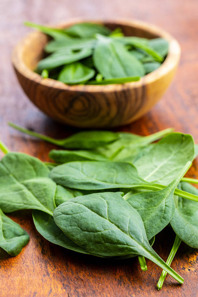 Baby spinach leaves. Green spinach on wooden table. - Foto, imagen
