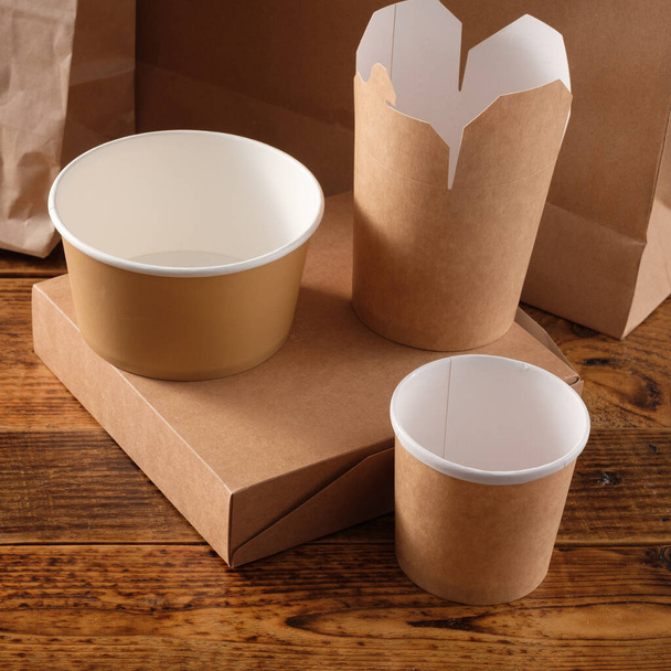 Street fast food paper cups, plates and containers. Eco-friendly food packaging on wooden background. Copy space. Carering of nature and recycling concept. - Fotoğraf, Görsel
