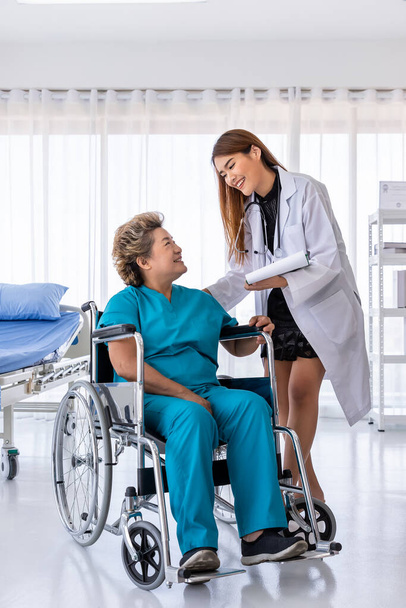 Asian medical doctor take care senior elderly woman female patient on wheelchair - Foto, Imagen