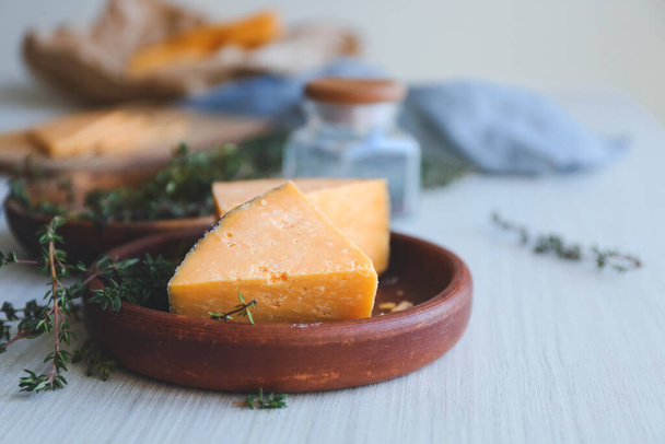 Plate with tasty cheese and thyme on white table - Fotoğraf, Görsel
