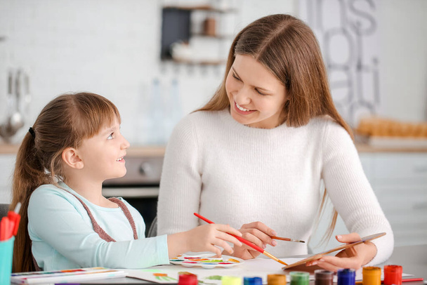 Profesora de dibujo dando clases privadas de arte a una niña en casa
 - Foto, Imagen