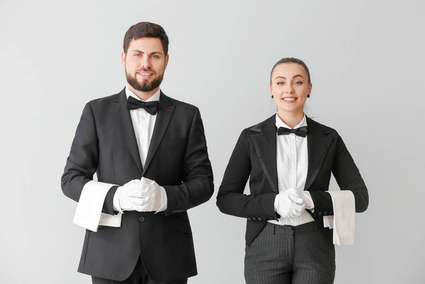 Male and female waiters on grey background - Fotoğraf, Görsel