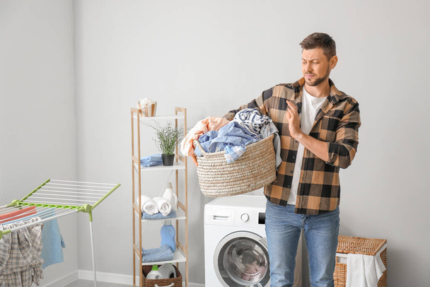 Displeased man doing laundry at home - Fotoğraf, Görsel