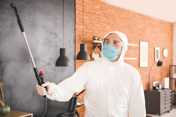 Trabajador en traje de riesgo biológico desinfectando casa - Foto, imagen