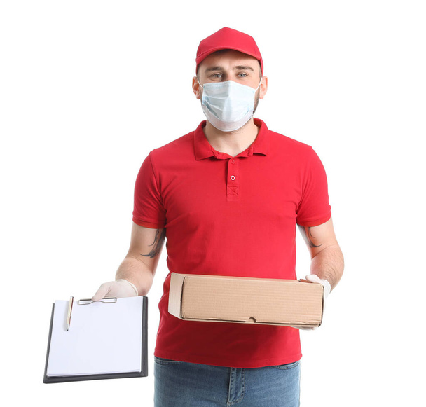 Männlicher Kurier in medizinischer Maske und mit Schachtel auf weißem Hintergrund - Foto, Bild