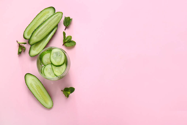 Glass of cucumber infused water on color background - Foto, Imagen