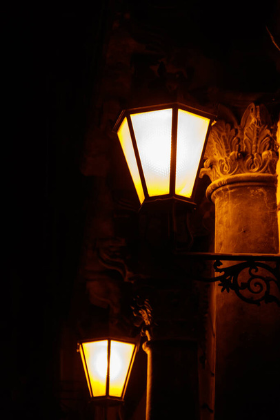 Zapalona latarnia uliczna vintage na ścianie domu w nocy - Zdjęcie, obraz