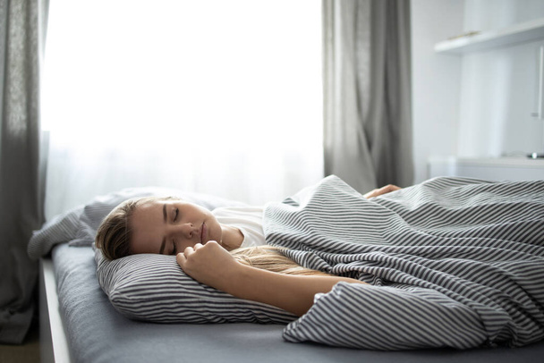 Pretty, young woman sleeping in her bed with her cell phone close to her. Smartphone in Bed Mobile/smartphone  Addiction Concept. - Foto, Bild