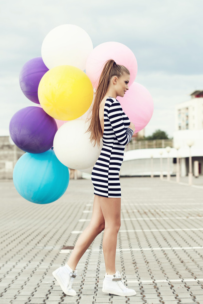Happy young woman with colorful latex balloons - Фото, зображення