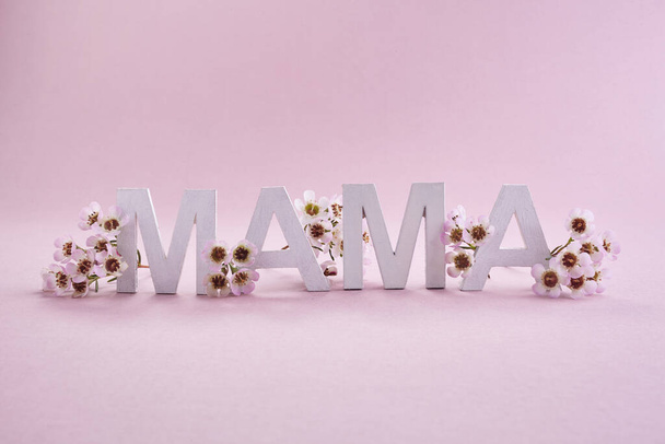 International word mama made from white wooden letters. Greeting card for Happy mother day. - Фото, зображення