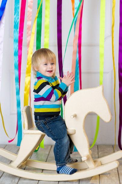 Cheerful toddler riding handmade wooden horse - Zdjęcie, obraz
