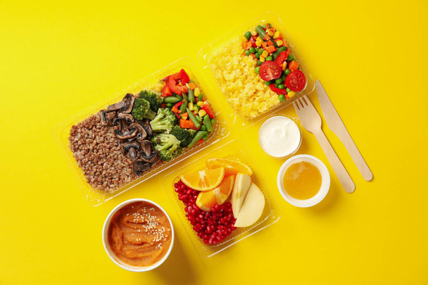 Food delivery. Food in takeaway boxes on yellow background - Fotó, kép