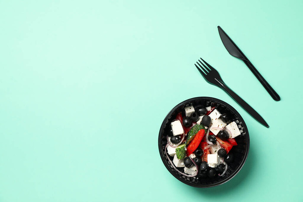 Food delivery. Salad in takeaway box on mint background - Фото, зображення