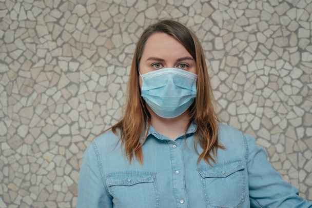 Λευκή ξανθιά γυναίκα με μπλε χειρουργική μάσκα και γάντια για ιατρική περίθαλψη. Εκφράσεις προσώπου για πανδημία. πορτρέτο Ευρωπαίας με προστατευτική μάσκα. Σταματήστε SARSCoV, ιός 2020, COVID-19. - Φωτογραφία, εικόνα