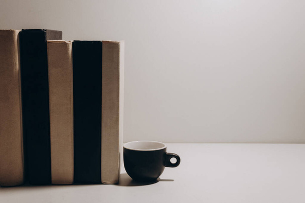 Livres noirs et blancs et tasse de café sur fond gris isolé
 - Photo, image
