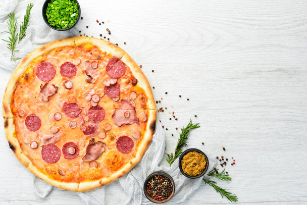 Homemade pizza with bacon and salami on the table. Rustic style. Top view. - Valokuva, kuva