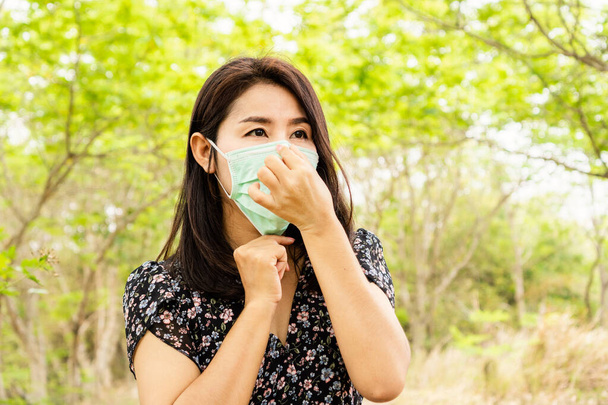 Femme asiatique portant des masques de protection contre le virus covid-19 marchant à l'extérieur dans un parc soins de santé et concept médical
 - Photo, image
