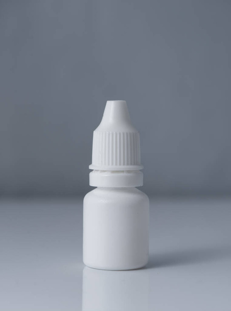 White plastic medical container on white, gray background - Fotografie, Obrázek