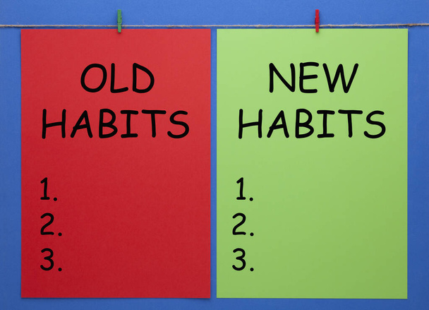 Viejos hábitos y nuevos hábitos escritos en hojas de papel de color con pizca de madera sobre fondo azul
. - Foto, Imagen