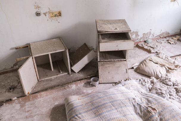 Verlaten ziekenhuiskamer in Pripyat, gebroken meubels, oude vuile nachtkastje, Tsjernobyl zone, Oekraïne - Foto, afbeelding