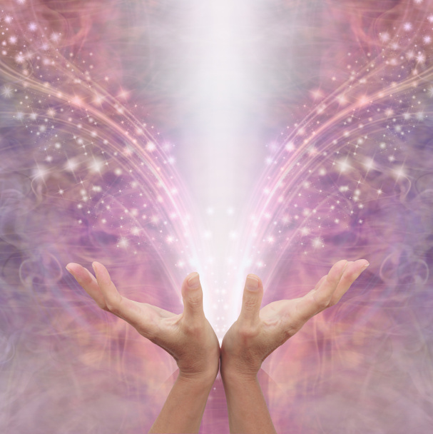 Envío de energía curativa Reiki a través del éter - hembra con las manos abiertas irradiando energía blanca contra un hermoso rosa brillante angelical etéreo fondo de energía con espacio de copia por encima
 - Foto, imagen