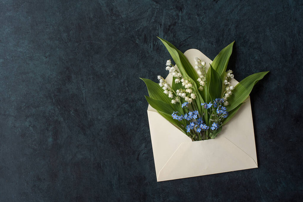 Anyák napi üdvözlőlap borítékkal és felejts el virágokkal és liliomokkal a völgyből. - Fotó, kép