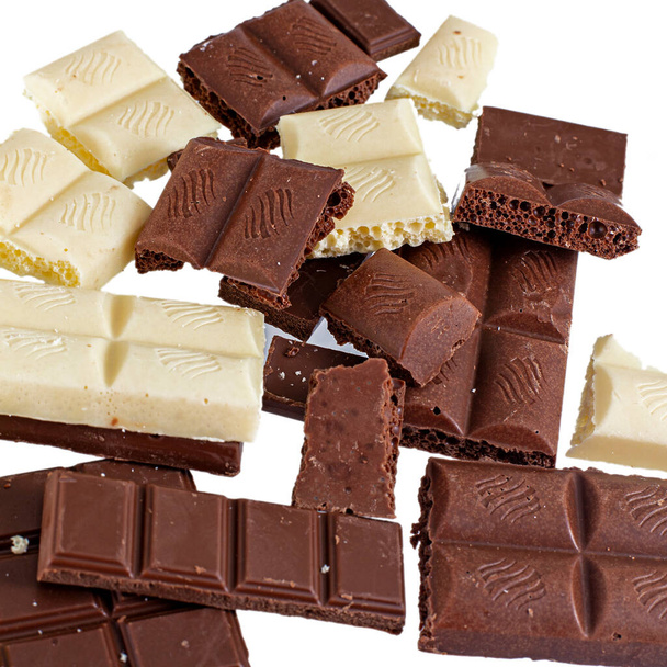 Crashed zwart-wit chocoladereep met grote hazelnoten, geïsoleerd op wit - Foto, afbeelding