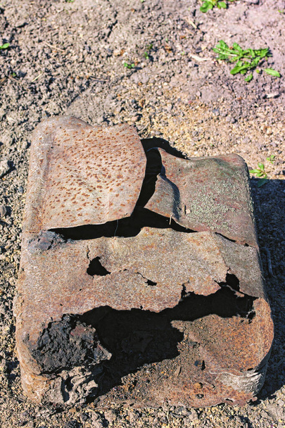 Close-up van een oude kapotte roestige jerrycan. Oud roestig metalen oppervlak met mos van jerrycan op de grond. Roest vernietigde de bodem van de jerrycan. Textuur of achtergrond. Abstracte metaalachtergrond. - Foto, afbeelding