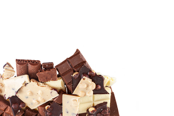 Crashed zwart-wit chocoladereep met grote hazelnoten, geïsoleerd op wit - Foto, afbeelding
