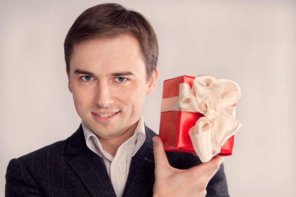 Portrét muže v obleku s dárkem v blízkosti obličeje (retro) - Fotografie, Obrázek