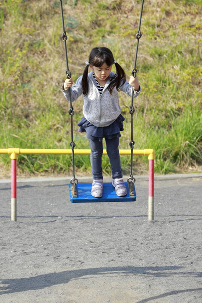 Giapponese ragazza in piedi su il swing (5 anni
) - Foto, immagini