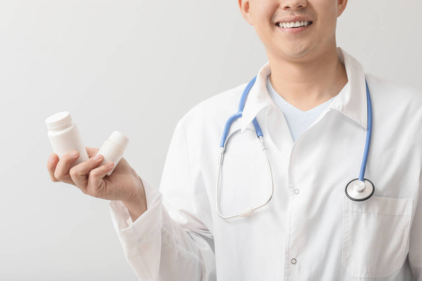 Arzt mit Pillen auf hellem Hintergrund - Foto, Bild