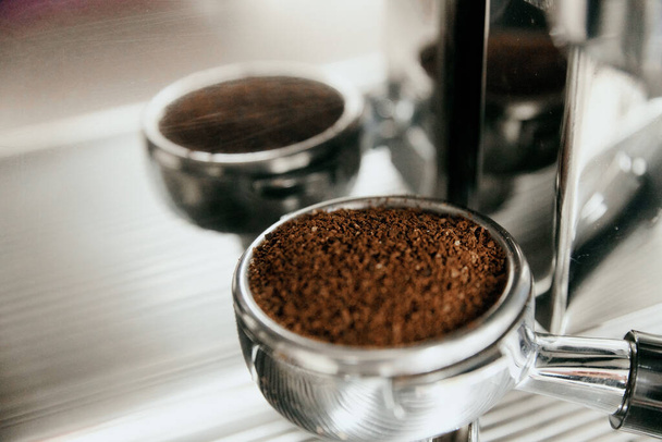 Freshly ground coffee in the holder for making a portion of coffee in the coffee machine - Foto, imagen