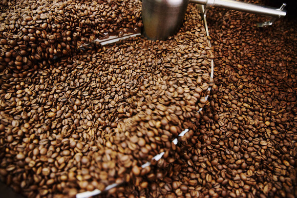Coffee brown roasted beans. The roasting process in the roaster - Foto, Imagen