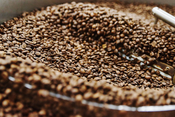 Coffee brown roasted beans. The roasting process in the roaster - Fotó, kép