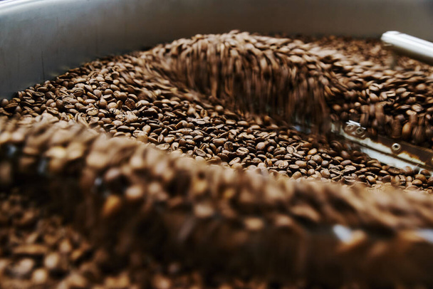 Coffee brown roasted beans. The roasting process in the roaster - Fotó, kép