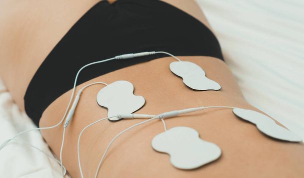 Frauenkörper mit Elektroden auf dem Rücken. Elektrische Muskelstimulation. - Foto, Bild