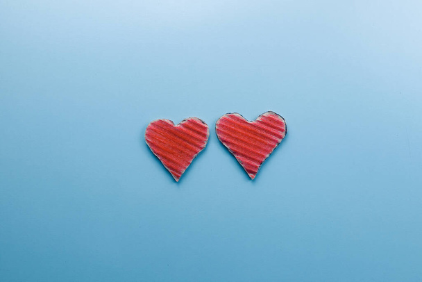 Deux coeurs en carton rouge sur fond bleu
 - Photo, image