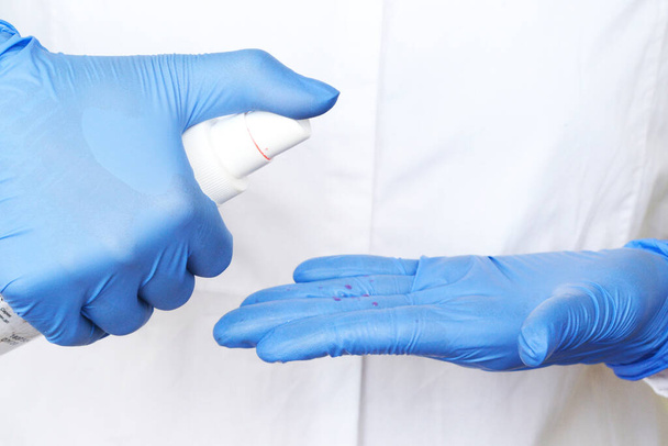 alcohol antiseptic gel and latex gloves,prevent against infection of Covid-19 outbreak,woman washing hands with hand sanitizer to avoid contaminating with Corona virus - Photo, Image