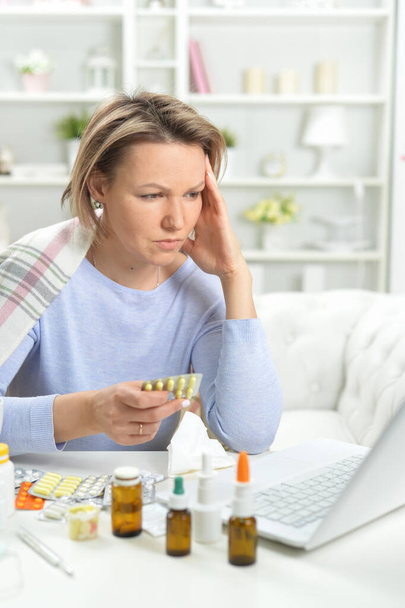 beautiful young woman with pills using laptop  - Photo, Image