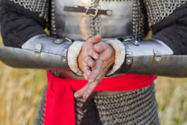 Handen van een middeleeuwse krijger, van dichtbij, bevlekt met aarde. Houdt de aarde in zijn handen. handen in de grond. - Foto, afbeelding