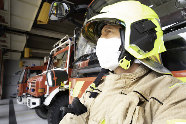 Pompier concentré équipé d'une combinaison et d'un masque d'intervention pour se protéger du covide 19
. - Photo, image