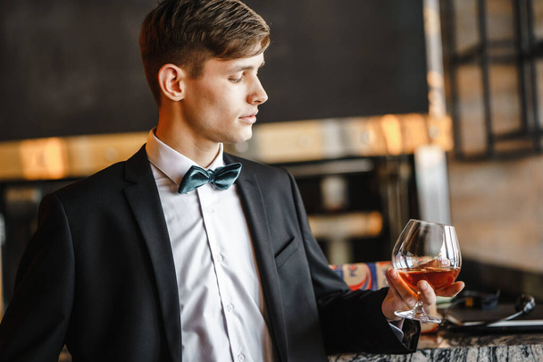 Ein Geschäftsmann hält ein Glas Wein in der Hand. - Foto, Bild