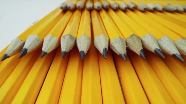 Les crayons jaunes s'étendent les uns sur les autres en rangs pairs. Macro 24 mm lentille Laowa. - Séquence, vidéo