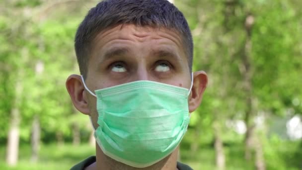 Sad unhappy man in a medical mask. Man in a protective mask with a sad face - Footage, Video